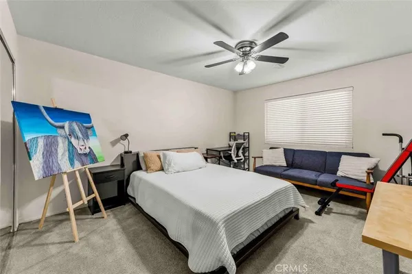a white bed sitting in a bedroom next to a window