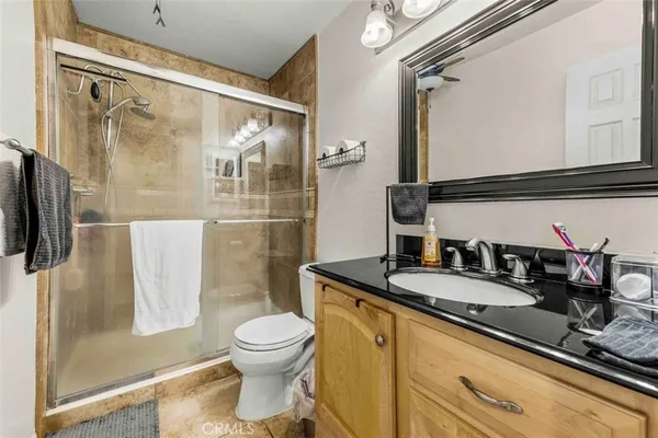a bathroom with a granite countertop sink toilet and shower