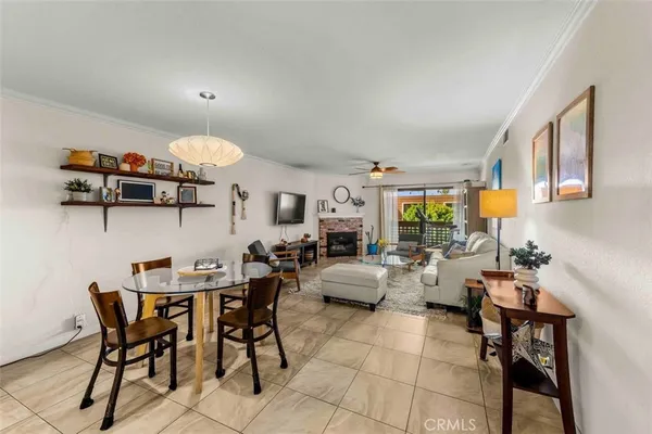 a view of a dining room and livingroom with furniture a rug a painting and a chandelier