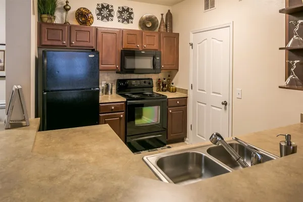 a kitchen with stainless steel appliances a stove a refrigerator and a sink