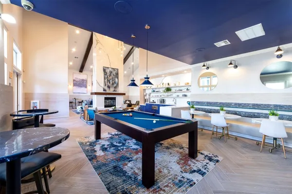 a room with furniture pool table and a large window