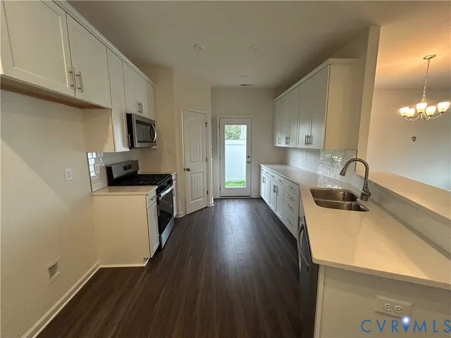 a kitchen with a sink a counter top space stainless steel appliances and cabinets