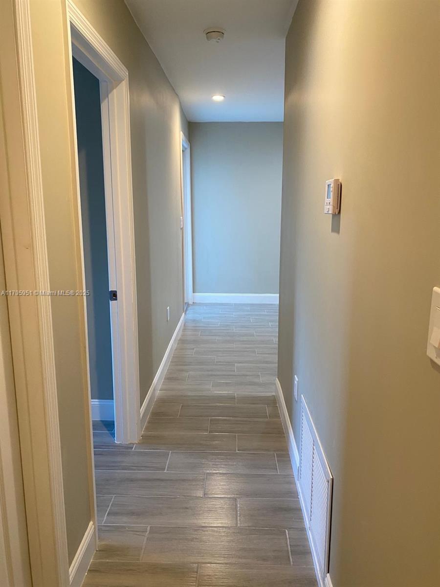 3906 Northwest 207 St Road, Unit 3906 Miami Gardens, FL 33055 - Photo 14 of 19 a view of a hallway with wooden floor