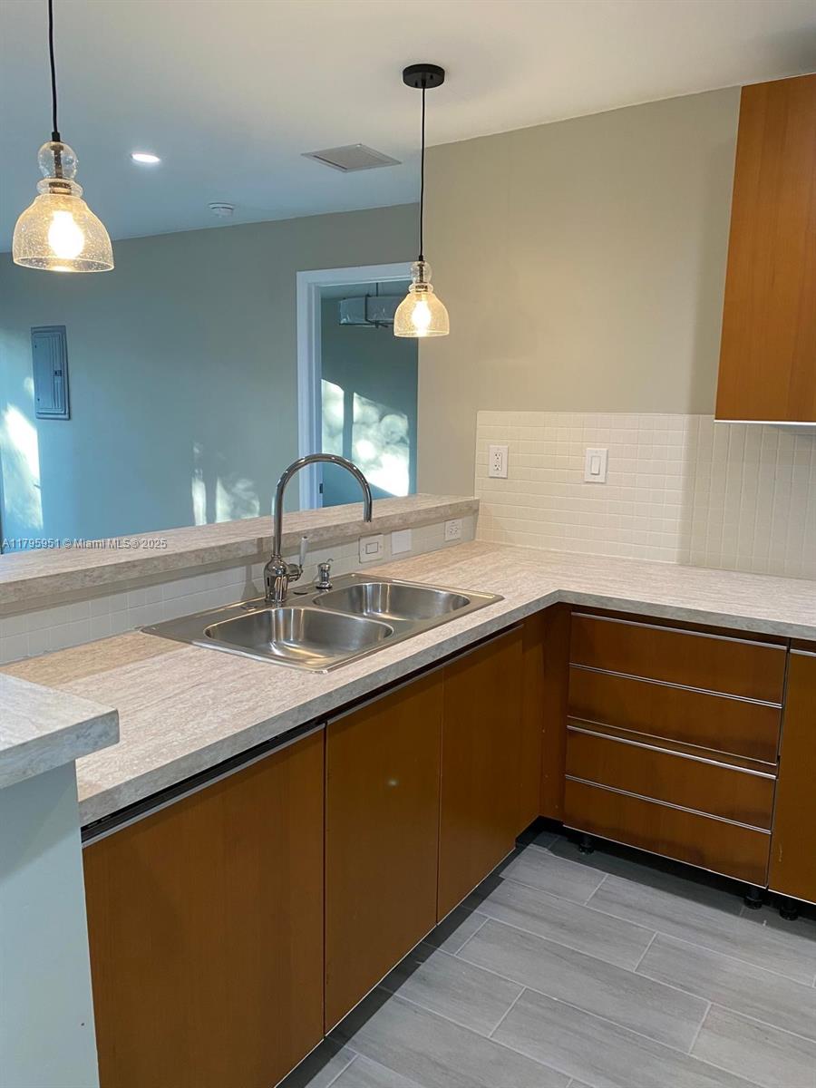 3906 Northwest 207 St Road, Unit 3906 Miami Gardens, FL 33055 - Photo 15 of 19 a kitchen with a sink a counter space and cabinets