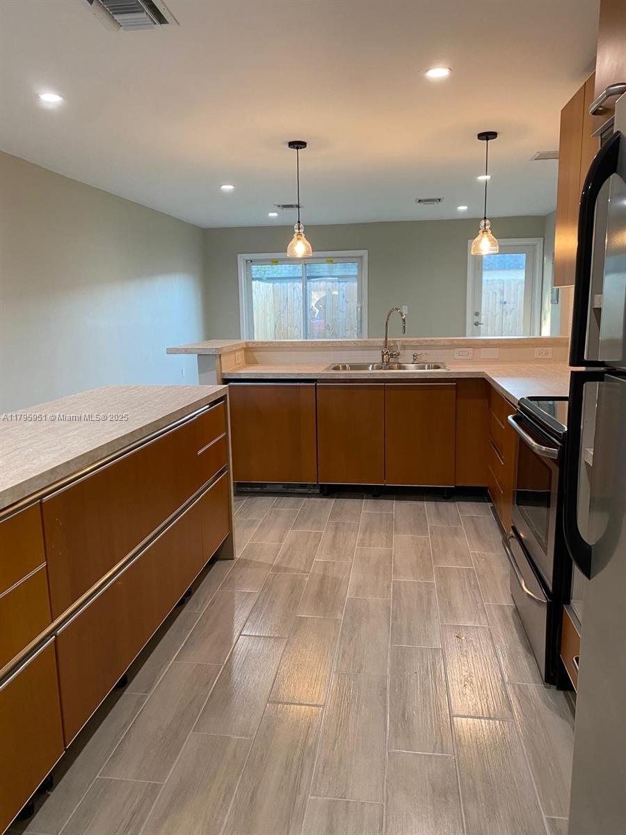 3906 Northwest 207 St Road, Unit 3906 Miami Gardens, FL 33055 - Photo 4 of 19 a kitchen with wooden cabinets and a sink