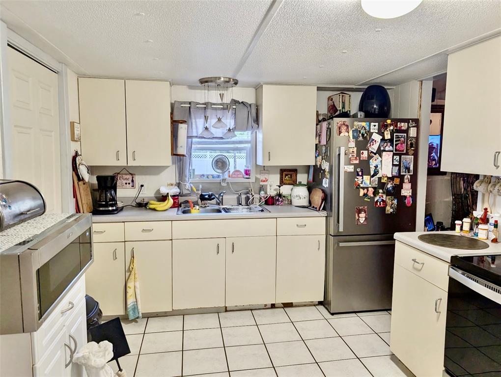 24302 Maxwell Street Astor, FL 32102 - Photo 5 of 11 a kitchen with stainless steel appliances a stove refrigerator sink and cabinets