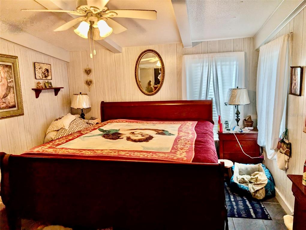 24302 Maxwell Street Astor, FL 32102 - Photo 6 of 11 a bedroom with a bed and a chandelier