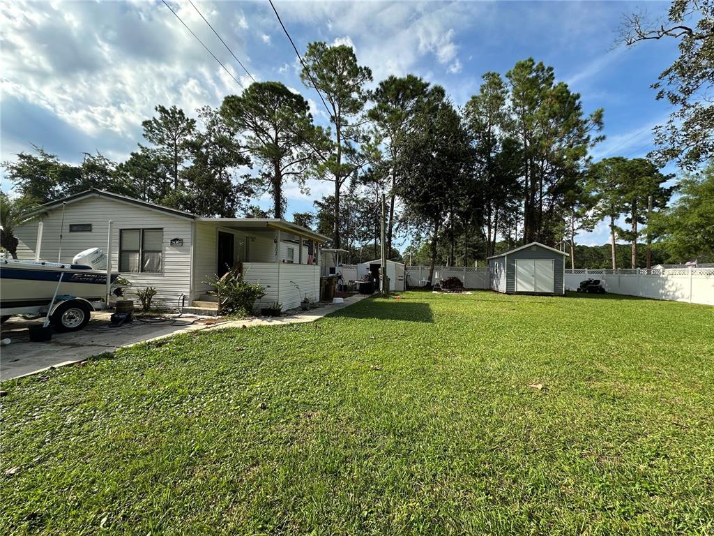 24302 Maxwell Street Astor, FL 32102 - Photo 8 of 11 a view of a house with backyard and a tree