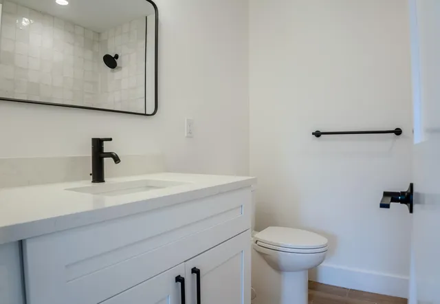 a bathroom with a sink a toilet and mirror