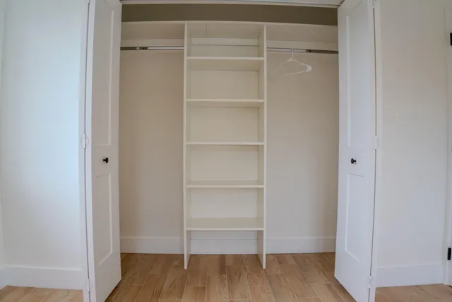 a view of walk in closet with empty racks