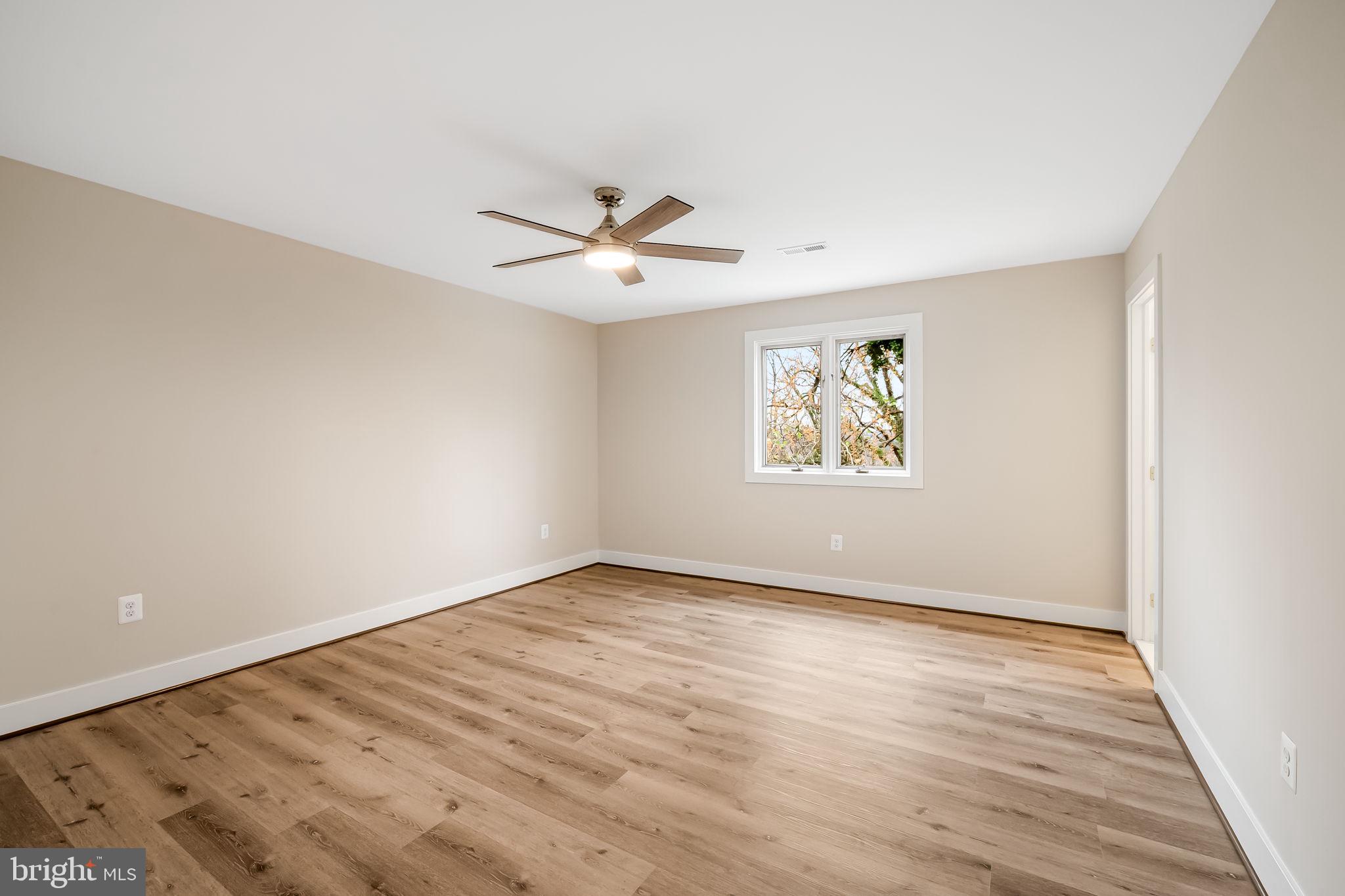113 Edgewood Road Towson, MD 21286 - Photo 16 of 48 an empty room with wooden floor chandelier fan and windows