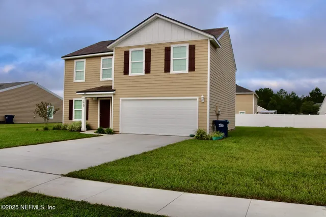 a front view of a house with a yard and garage