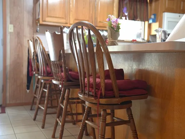 a large living room with couches a flat tv screen and kitchen view