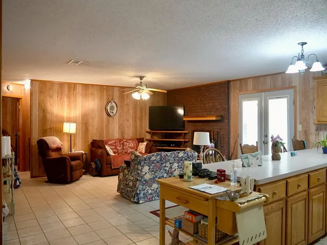 a kitchen with granite countertop a refrigerator a stove a sink a dining table and chairs