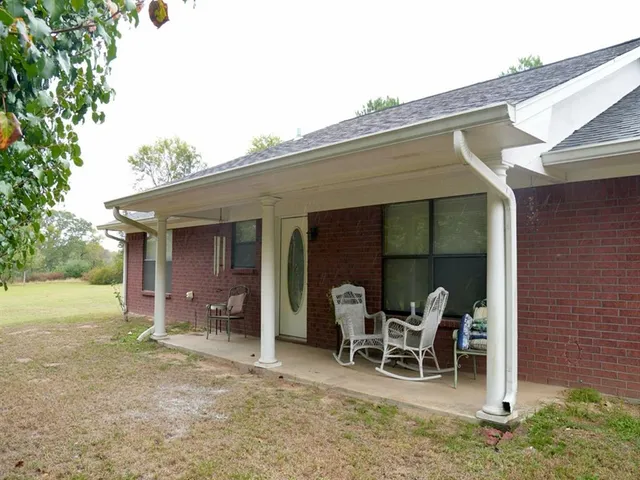 a view of a patio with table and chairs near a yard