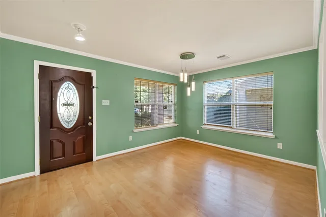 a view of a room with window wooden floor and front door