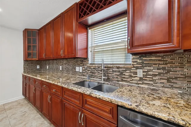 a kitchen with granite countertop cabinets sink and wooden cabinets