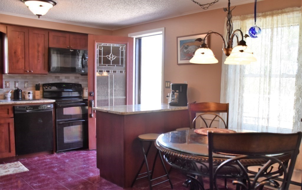 23 Bernie Road Holland, MA 01521 - Photo 8 of 36 a kitchen with a table chairs a refrigerator and a window