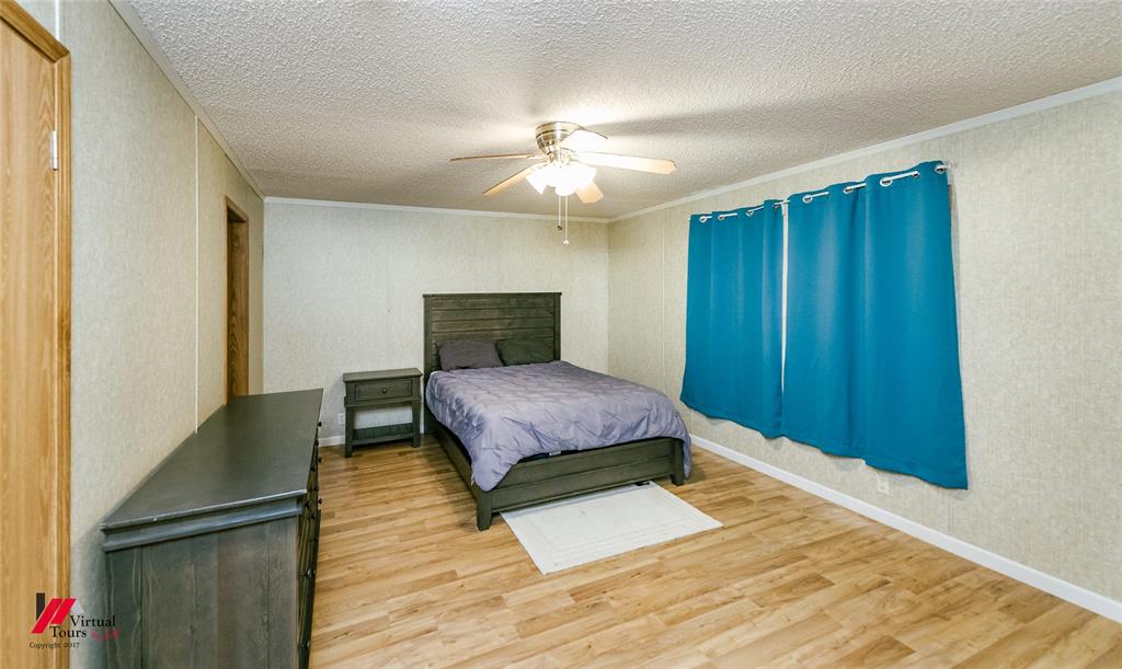 259 Kings Circle Grand Cane, LA 71032 - Photo 22 of 38 a bedroom with a bed and a chandelier