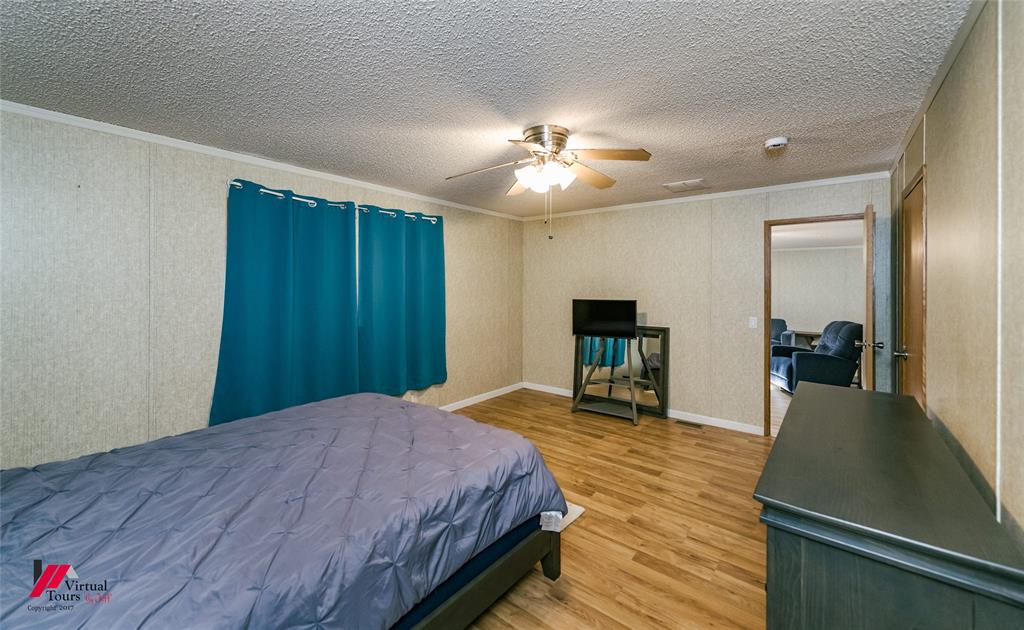 259 Kings Circle Grand Cane, LA 71032 - Photo 23 of 38 a spacious bedroom with a bed and a chandelier
