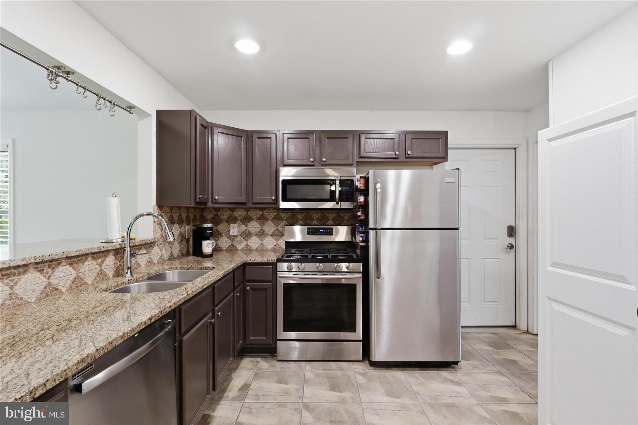 515 Shelton Shop Road Stafford, VA 22554 - Photo 17 of 52 a kitchen with stainless steel appliances granite countertop a refrigerator a stove a sink and a microwave