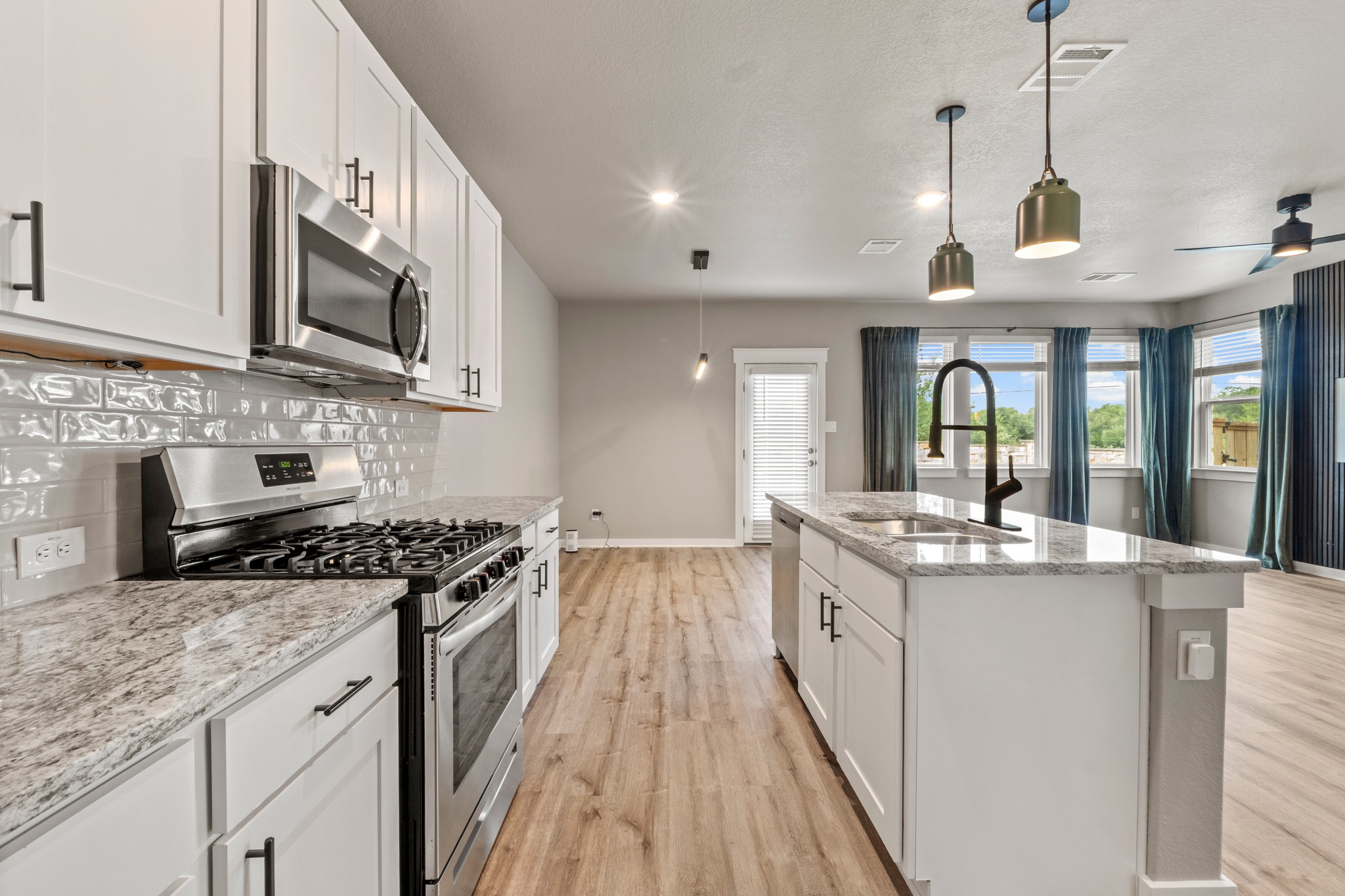 2251 Rocoso Trail Leander, TX 78641 - Photo 12 of 34 Gleaming stone countertops and modern cabinetry highlight this open-concept culinary space.