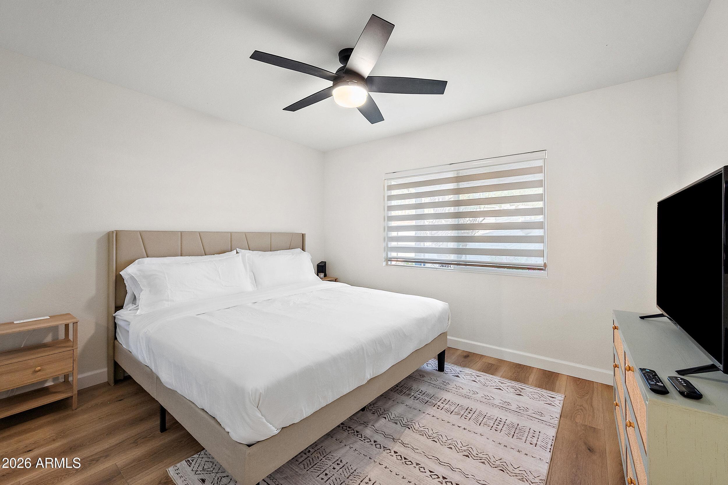 3911 North 13th Way Phoenix, AZ 85014 - Photo 12 of 34 a bedroom with a bed tv and a window