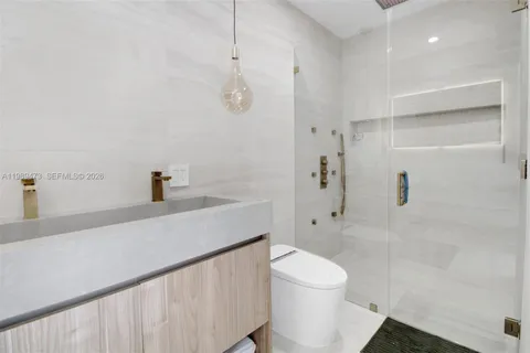 a bathroom with a sink a toilet and shower