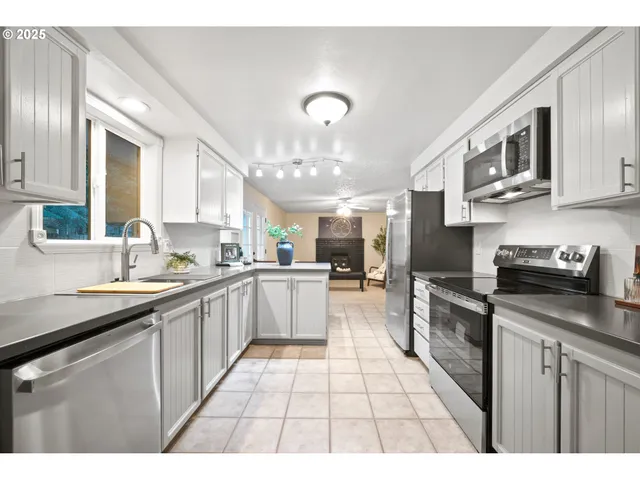 a kitchen with stainless steel appliances granite countertop a sink and stove top oven