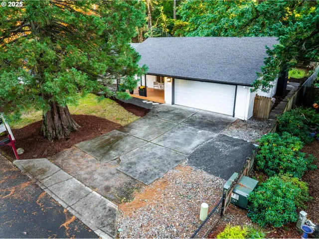 a aerial view of a house with a yard and large tree
