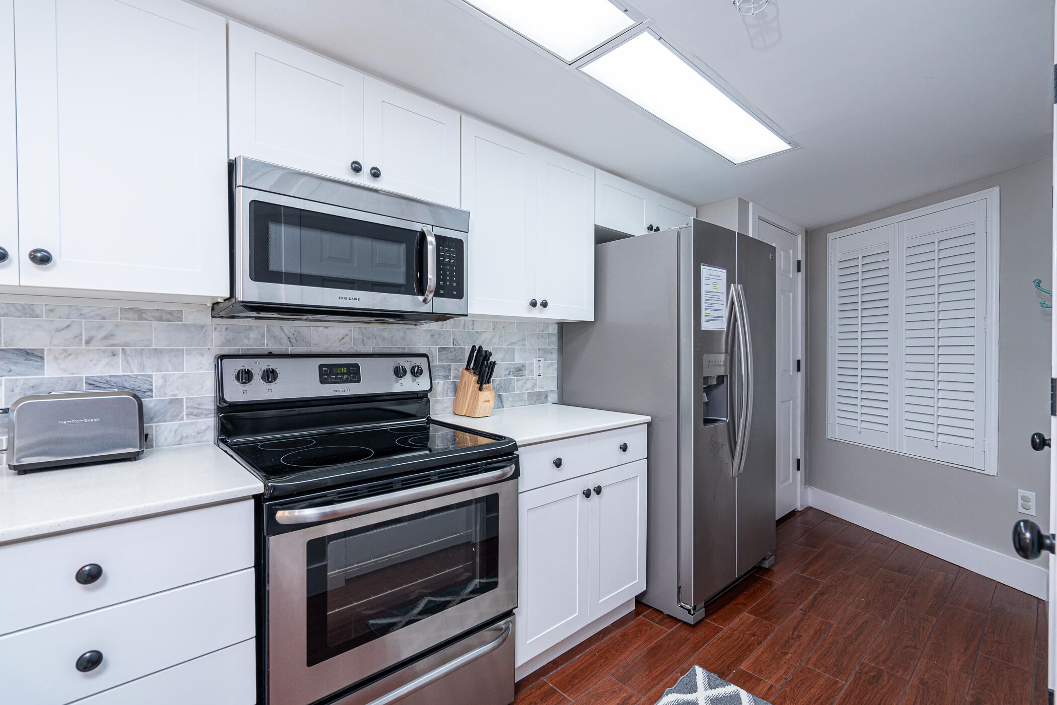 895 Santa Rosa Boulevard, Unit 308 Fort Walton Beach, FL 32548 - Photo 4 of 31 a kitchen with cabinets stainless steel appliances and wooden floor