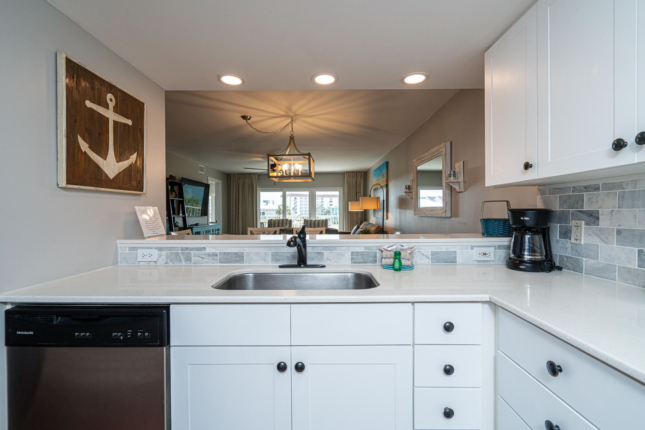 895 Santa Rosa Boulevard, Unit 308 Fort Walton Beach, FL 32548 - Photo 5 of 31 a kitchen with kitchen island white cabinets and white appliances