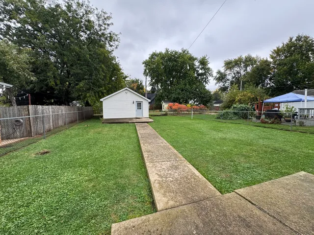 a view of a house with a yard and sitting area