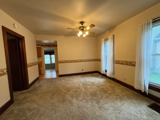 an empty room with closet and a ceiling fan