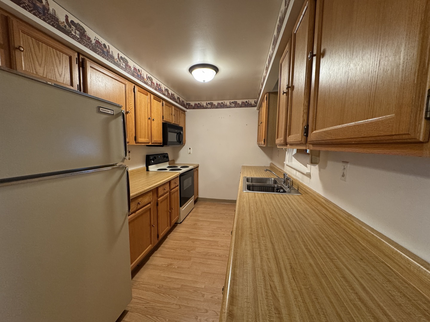 138 North Brown Street Genoa, IL 60135 - Photo 8 of 30 a kitchen with granite countertop a refrigerator a stove and wooden floor