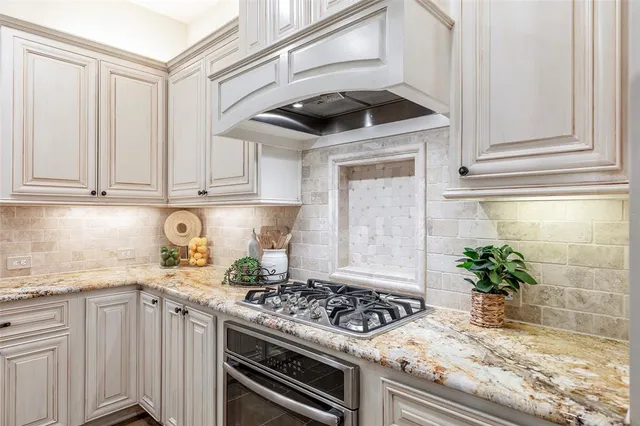 a kitchen with granite countertop a stove and cabinets