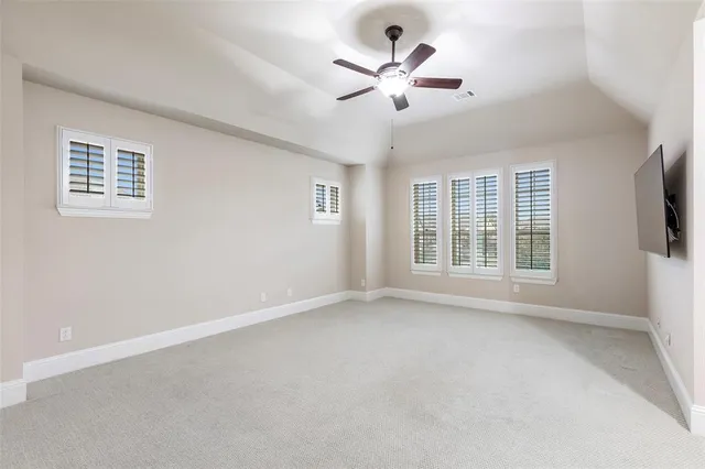 a view of an empty room with a window and a ceiling fan
