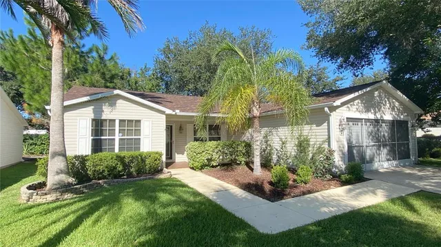 a view of a house with a yard and potted plants