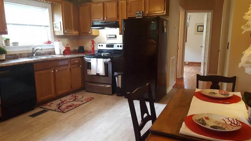 2412 Dugspur Road Callaway, VA 24067 - Photo 12 of 35 a kitchen with stainless steel appliances granite countertop a refrigerator a stove a sink dishwasher and a dining table with wooden cabinet
