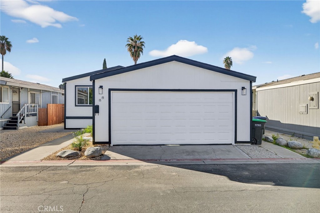 80 Dawes Street, Unit 88 Perris, CA 92571 - Photo 2 of 29 a front view of a house with a yard and garage