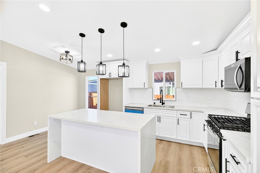 80 Dawes Street, Unit 88 Perris, CA 92571 - Photo 8 of 29 a kitchen with a sink a stove a refrigerator and white cabinets