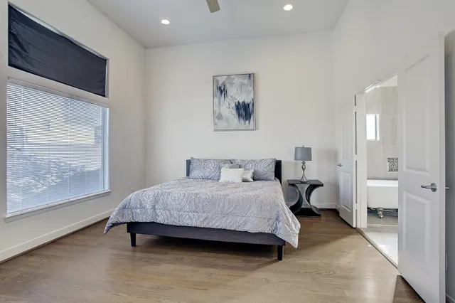 a spacious bedroom with a bed and a large window