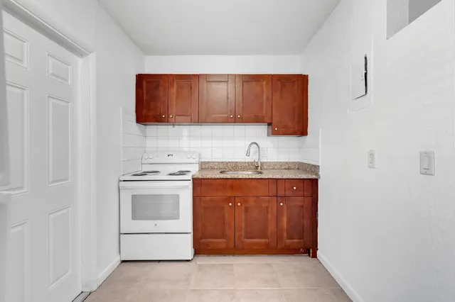 a kitchen with a sink and a stove top oven