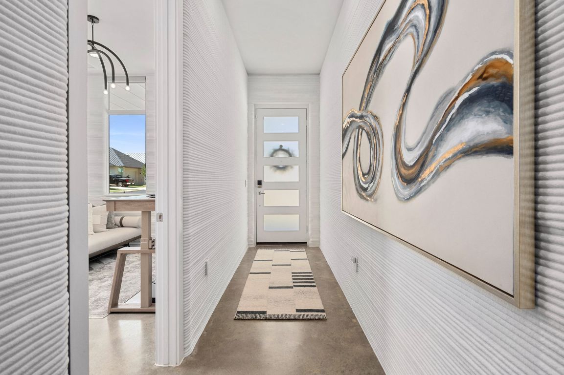 221 Lone Ranger Trail Georgetown, TX 78628 - Photo 4 of 35 a hallway with white doors wooden floor and stairs