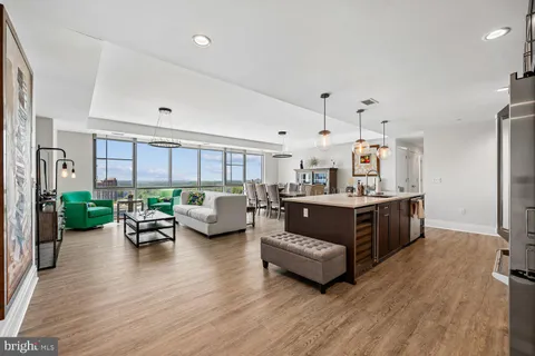 a large kitchen with kitchen island a large counter space a sink a stove and a center island
