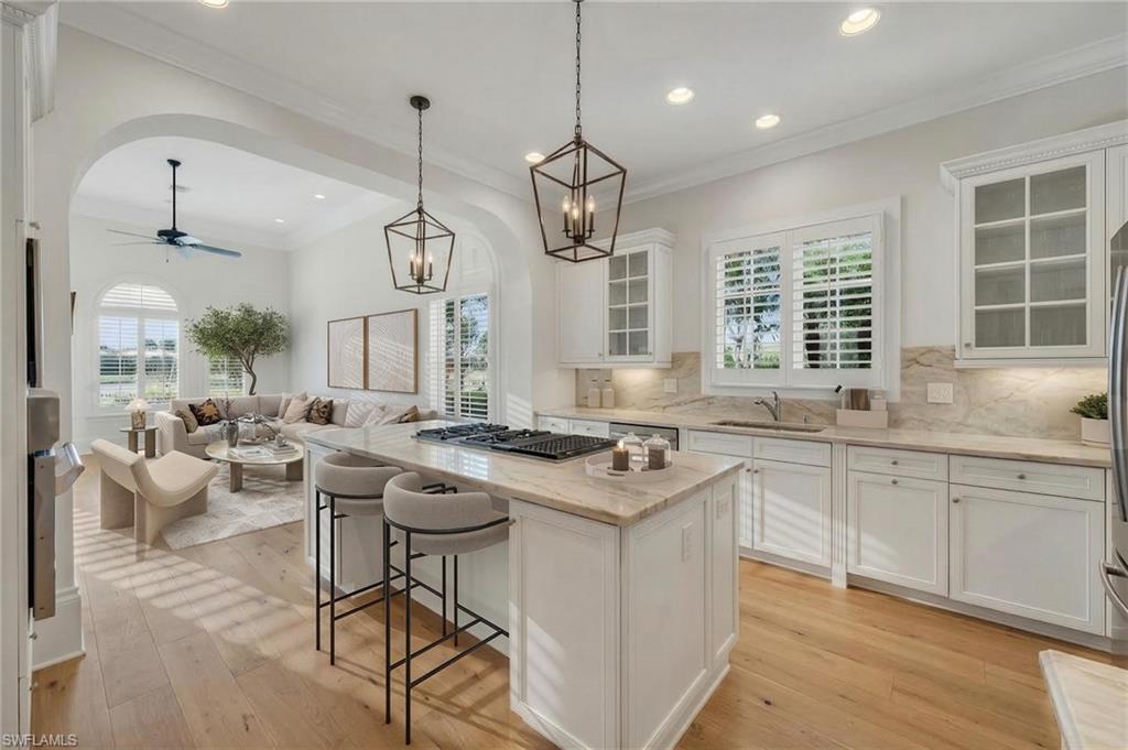 2629 Sorrel Way Naples, FL 34105 - Photo 21 of 43 a kitchen with stainless steel appliances granite countertop a stove a sink dishwasher a dining table and chairs with wooden floor