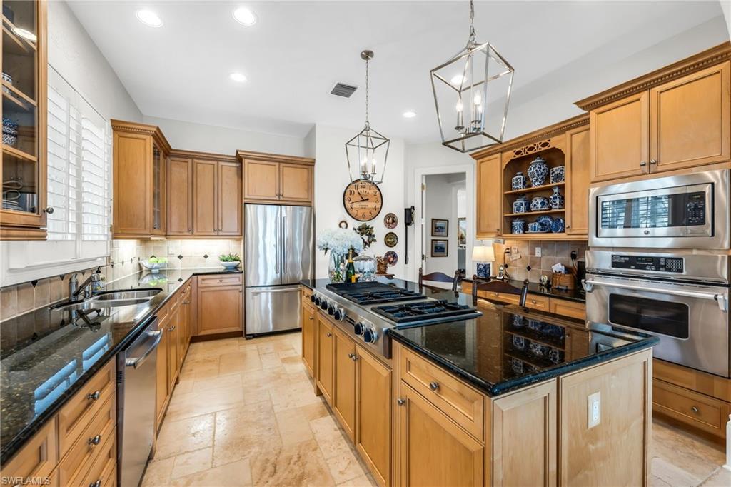 2629 Sorrel Way Naples, FL 34105 - Photo 25 of 43 a kitchen with granite countertop a sink stove and refrigerator