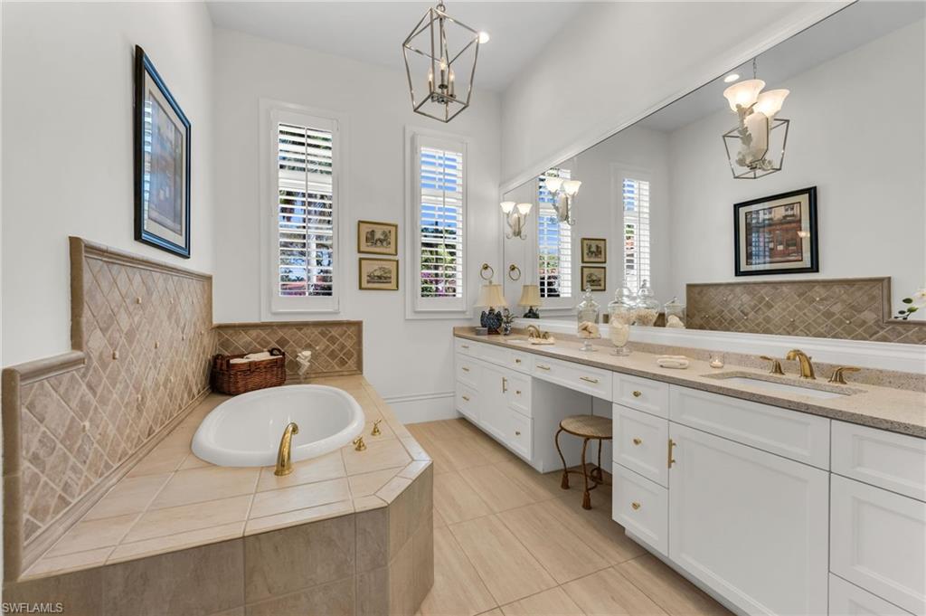2629 Sorrel Way Naples, FL 34105 - Photo 29 of 43 a bathroom with a granite countertop sink a mirror and a bathtub