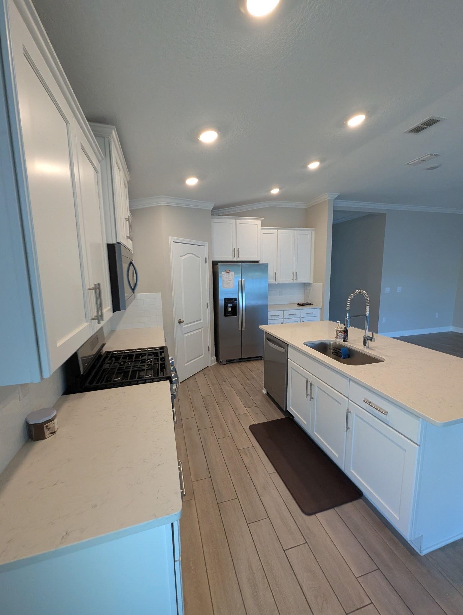721 Navarez Street St. Augustine, FL 32084 - Photo 33 of 34 a large kitchen with stainless steel appliances a large counter top a stove and a refrigerator