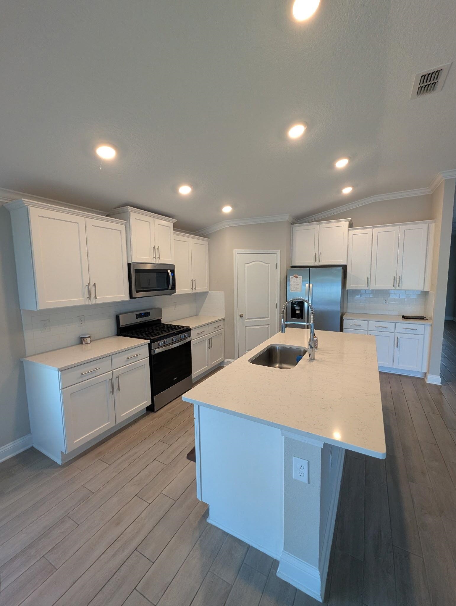 721 Navarez Street St. Augustine, FL 32084 - Photo 34 of 34 a large kitchen with kitchen island a sink a stove a refrigerator and white cabinets